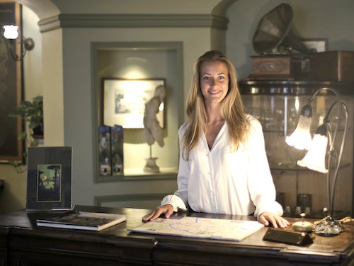 Smiling woman at a concierge desk.